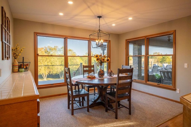 carpeted dining space with a notable chandelier and plenty of natural light