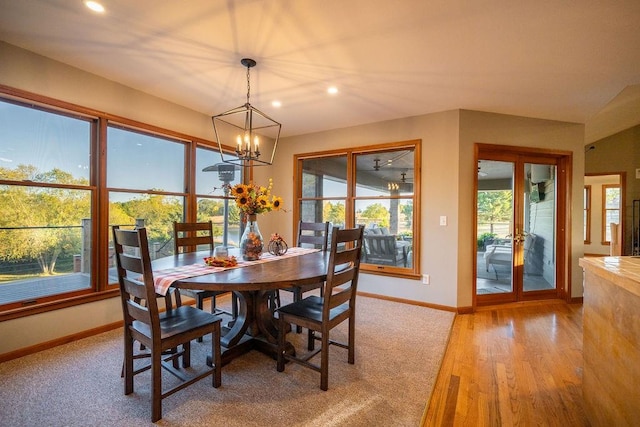 dining room with light hardwood / wood-style flooring and an inviting chandelier