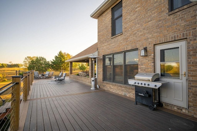 deck at dusk featuring grilling area