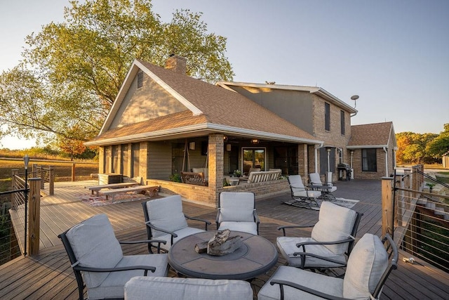 wooden deck featuring a fire pit and a grill