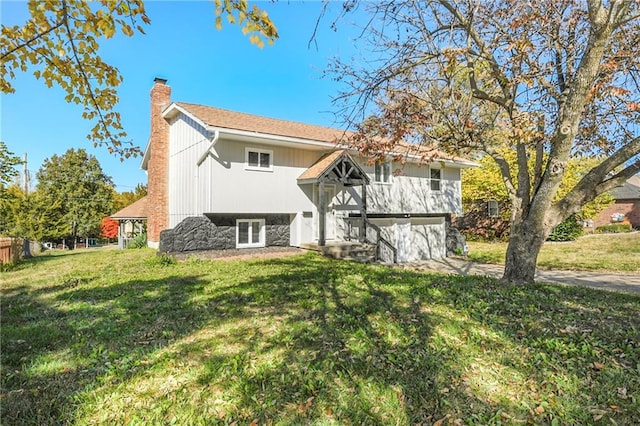 back of property with a garage and a yard