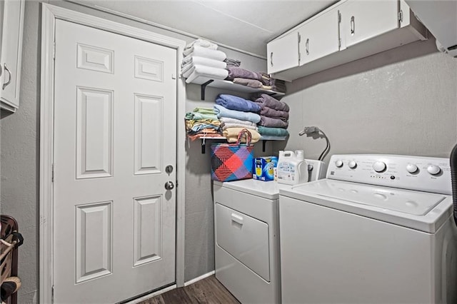 laundry room with washing machine and dryer, cabinets, and dark hardwood / wood-style floors