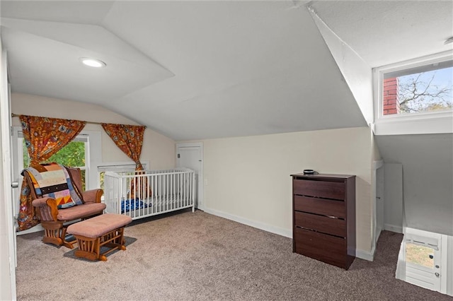 bedroom with carpet, vaulted ceiling, and a crib