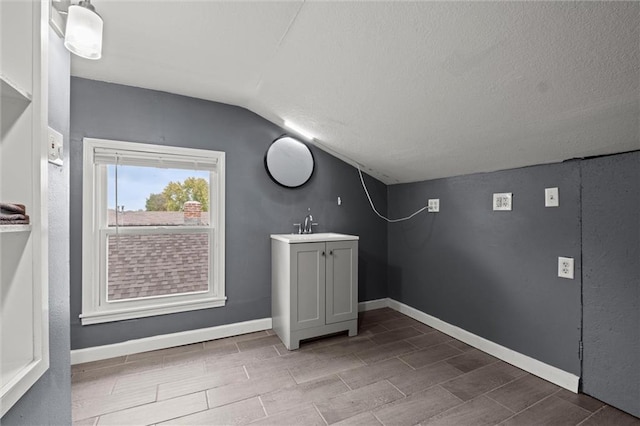 clothes washing area featuring sink and a textured ceiling