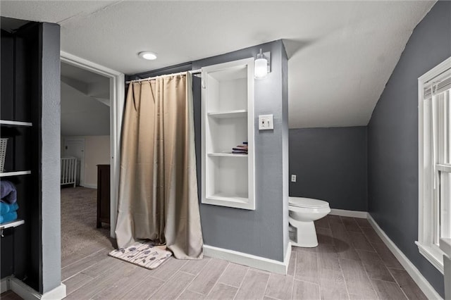 bathroom featuring lofted ceiling, hardwood / wood-style flooring, and toilet