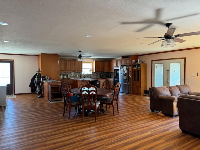 dining area with ornamental molding, dark hardwood / wood-style flooring, french doors, and plenty of natural light