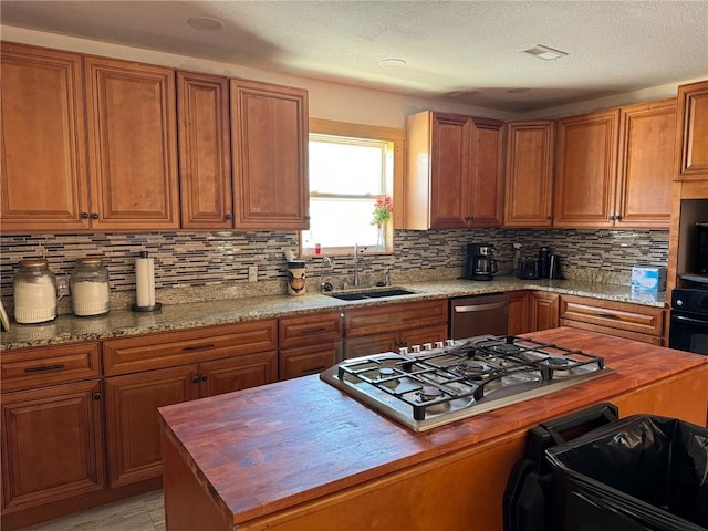 kitchen featuring sink, butcher block countertops, backsplash, and appliances with stainless steel finishes