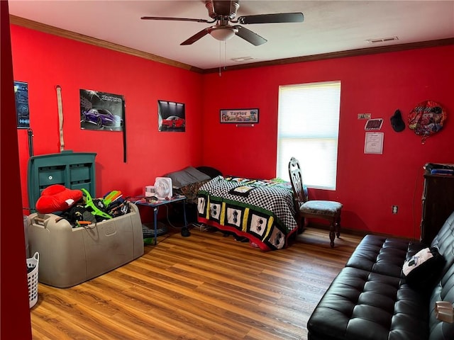 bedroom with ceiling fan, hardwood / wood-style floors, and crown molding