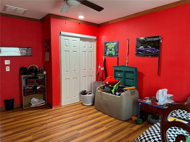 interior space featuring ceiling fan, ornamental molding, and hardwood / wood-style flooring