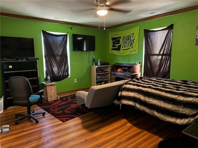 bedroom featuring ceiling fan, crown molding, and wood-type flooring