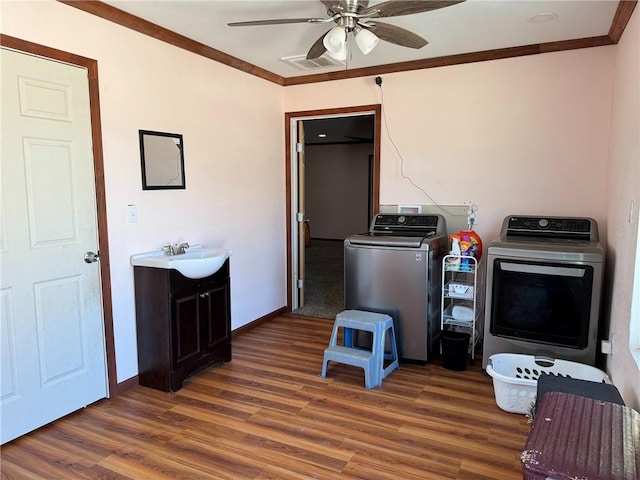 washroom featuring washer and dryer, crown molding, ceiling fan, dark hardwood / wood-style floors, and sink