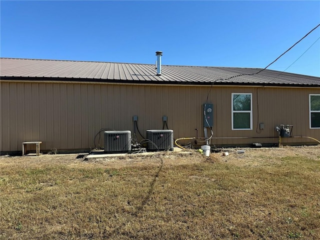 view of side of property featuring central air condition unit and a yard