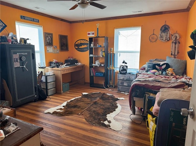 bedroom featuring hardwood / wood-style flooring, ceiling fan, and crown molding