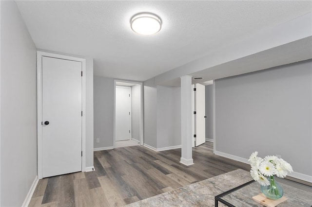 basement featuring a textured ceiling and dark wood-type flooring