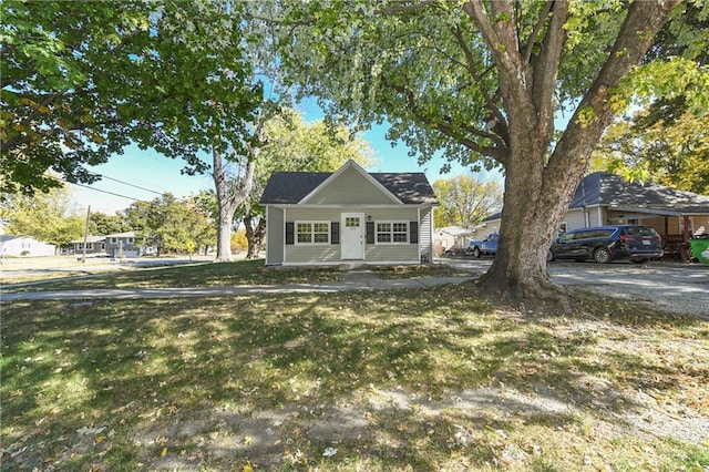 bungalow-style home with a front yard