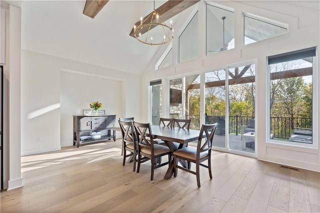 sunroom with an inviting chandelier and lofted ceiling with beams