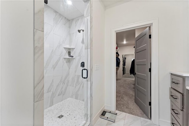 bathroom featuring a shower with door and vanity