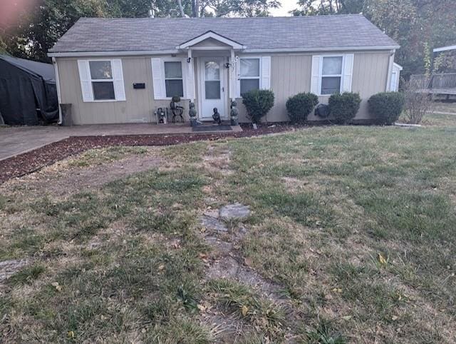 ranch-style home with a front yard and a patio area