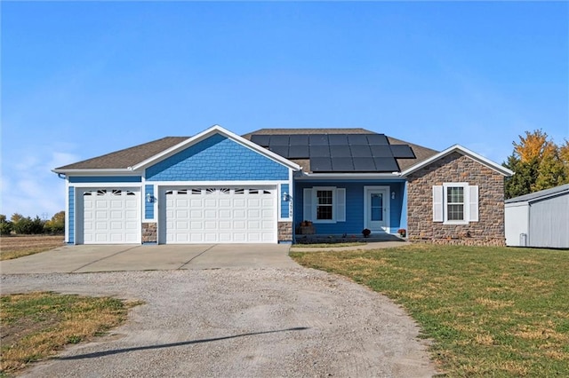 view of front of house featuring solar panels, a front lawn, and a garage