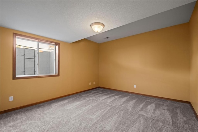 empty room with a textured ceiling and carpet floors