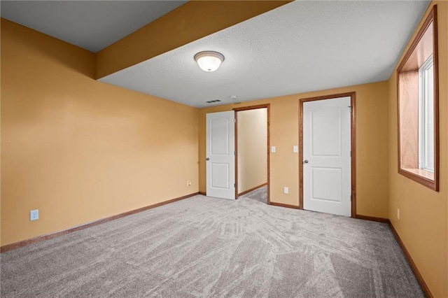 unfurnished bedroom featuring multiple windows and light colored carpet