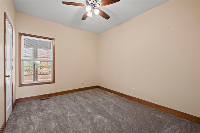 empty room featuring dark carpet and ceiling fan