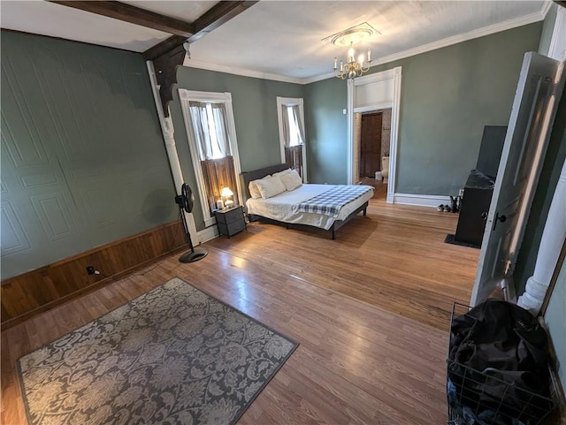 bedroom featuring crown molding, wood-type flooring, a chandelier, and wooden walls