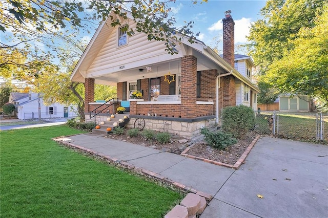 view of front of property with a porch and a front lawn