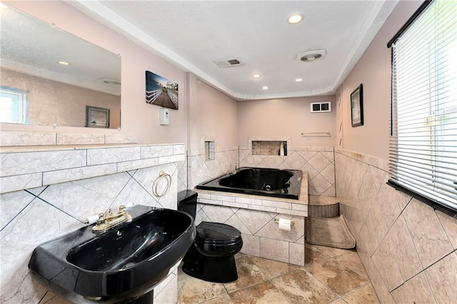 bathroom with tile walls, sink, toilet, and a bathing tub