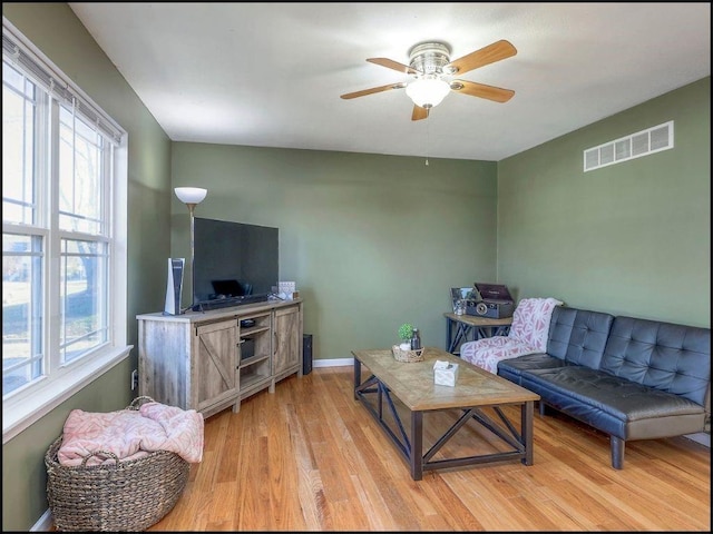 living room with light hardwood / wood-style flooring and ceiling fan