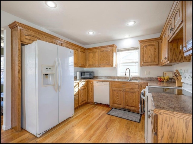 kitchen with white appliances, light hardwood / wood-style floors, and sink