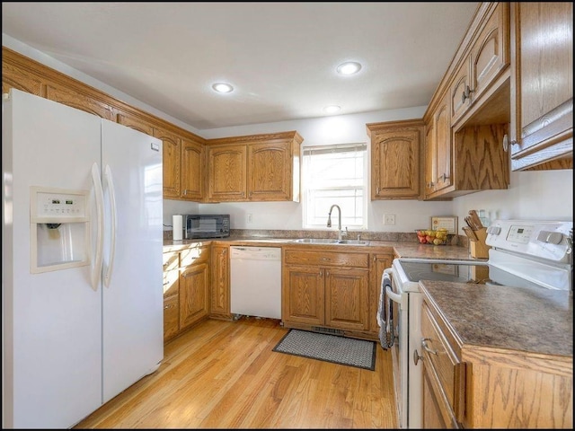 kitchen with white appliances, sink, and light hardwood / wood-style flooring