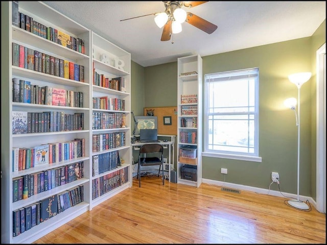 office with light hardwood / wood-style floors and ceiling fan