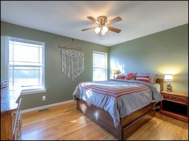 bedroom featuring light hardwood / wood-style floors, multiple windows, and ceiling fan