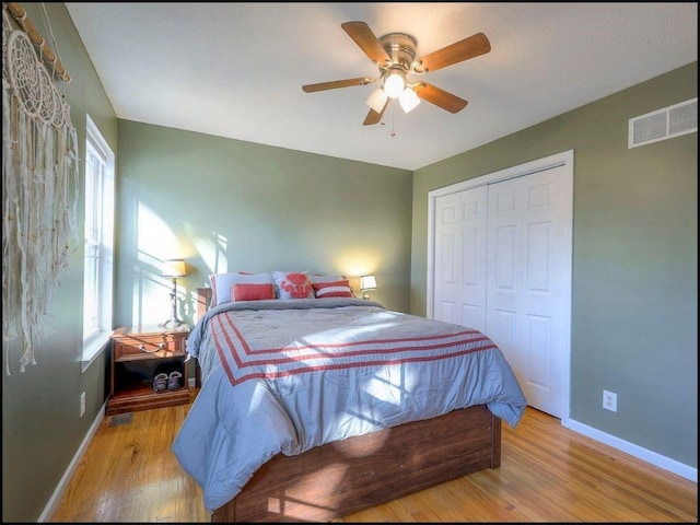 bedroom featuring ceiling fan, a closet, and light wood-type flooring