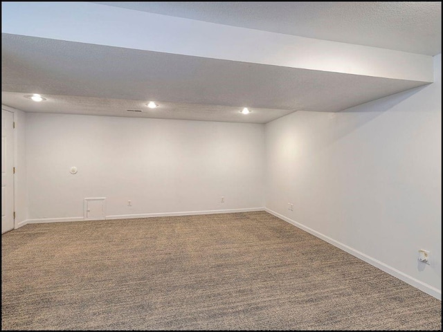 basement featuring carpet flooring and a textured ceiling