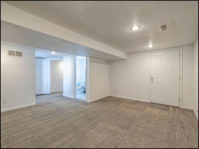 basement with carpet flooring and a textured ceiling