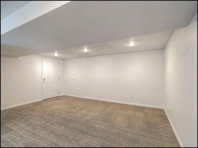 basement with dark colored carpet and a textured ceiling