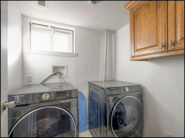 clothes washing area with cabinets, independent washer and dryer, and a textured ceiling