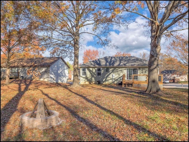 back of property with a lawn and a deck