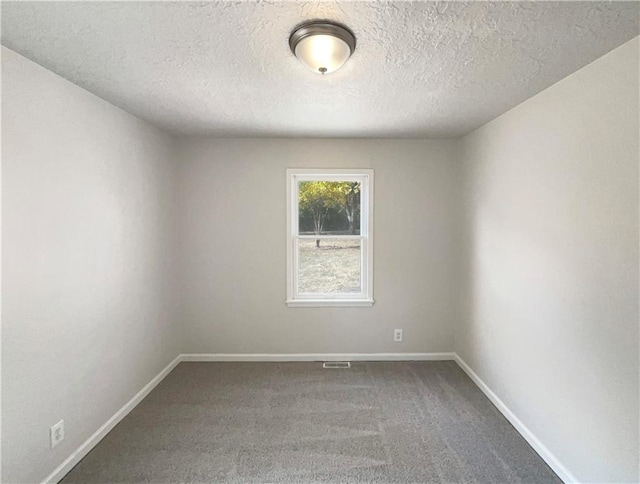 carpeted spare room with a textured ceiling