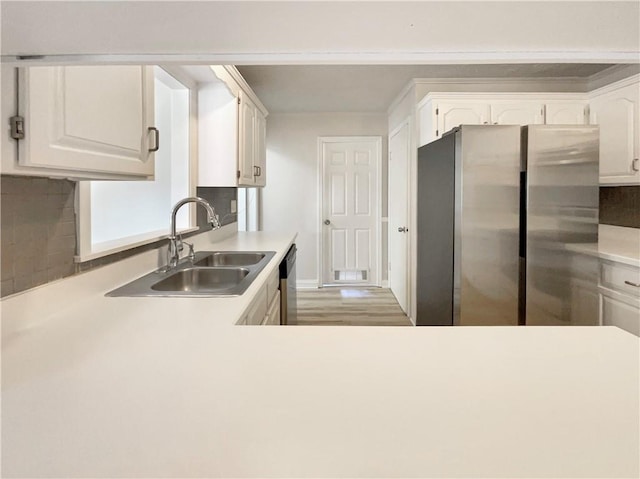 kitchen with white cabinetry, tasteful backsplash, stainless steel appliances, and sink