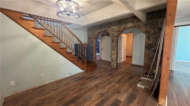 entrance foyer featuring a notable chandelier, coffered ceiling, and dark wood-type flooring