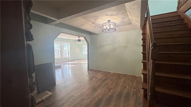 unfurnished dining area with hardwood / wood-style floors and ceiling fan with notable chandelier