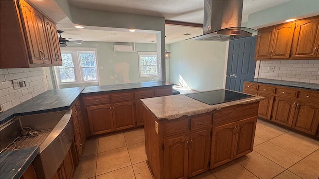 kitchen featuring kitchen peninsula, island exhaust hood, a wall mounted air conditioner, black electric stovetop, and a center island