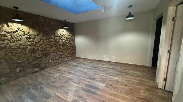 unfurnished room with dark hardwood / wood-style floors and a skylight