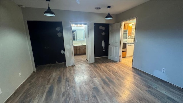 interior space featuring ensuite bathroom and dark wood-type flooring