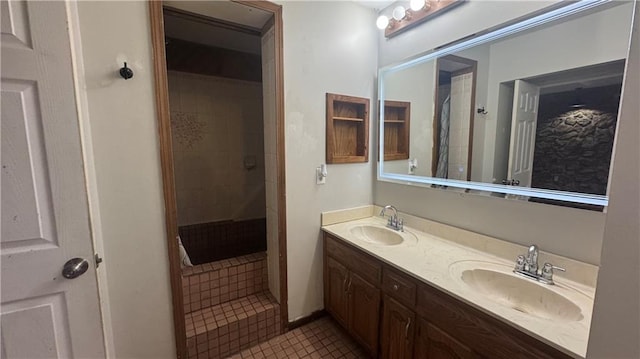 bathroom with a shower with door, vanity, and tile patterned floors