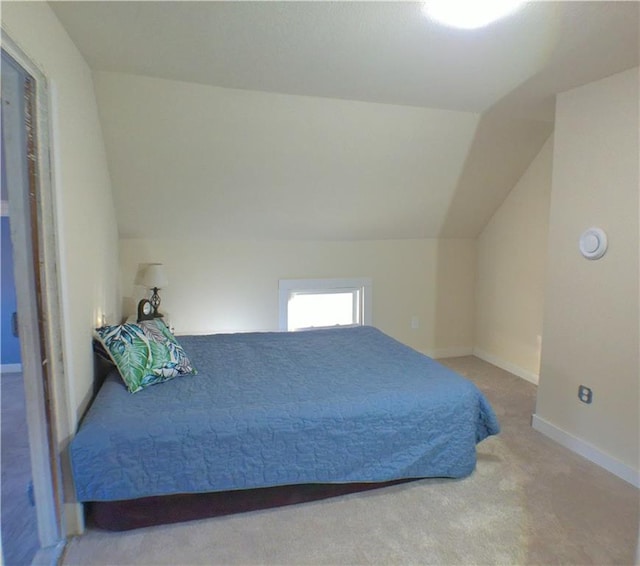 carpeted bedroom with lofted ceiling