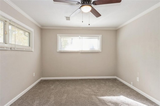 carpeted spare room featuring ceiling fan, a healthy amount of sunlight, and ornamental molding